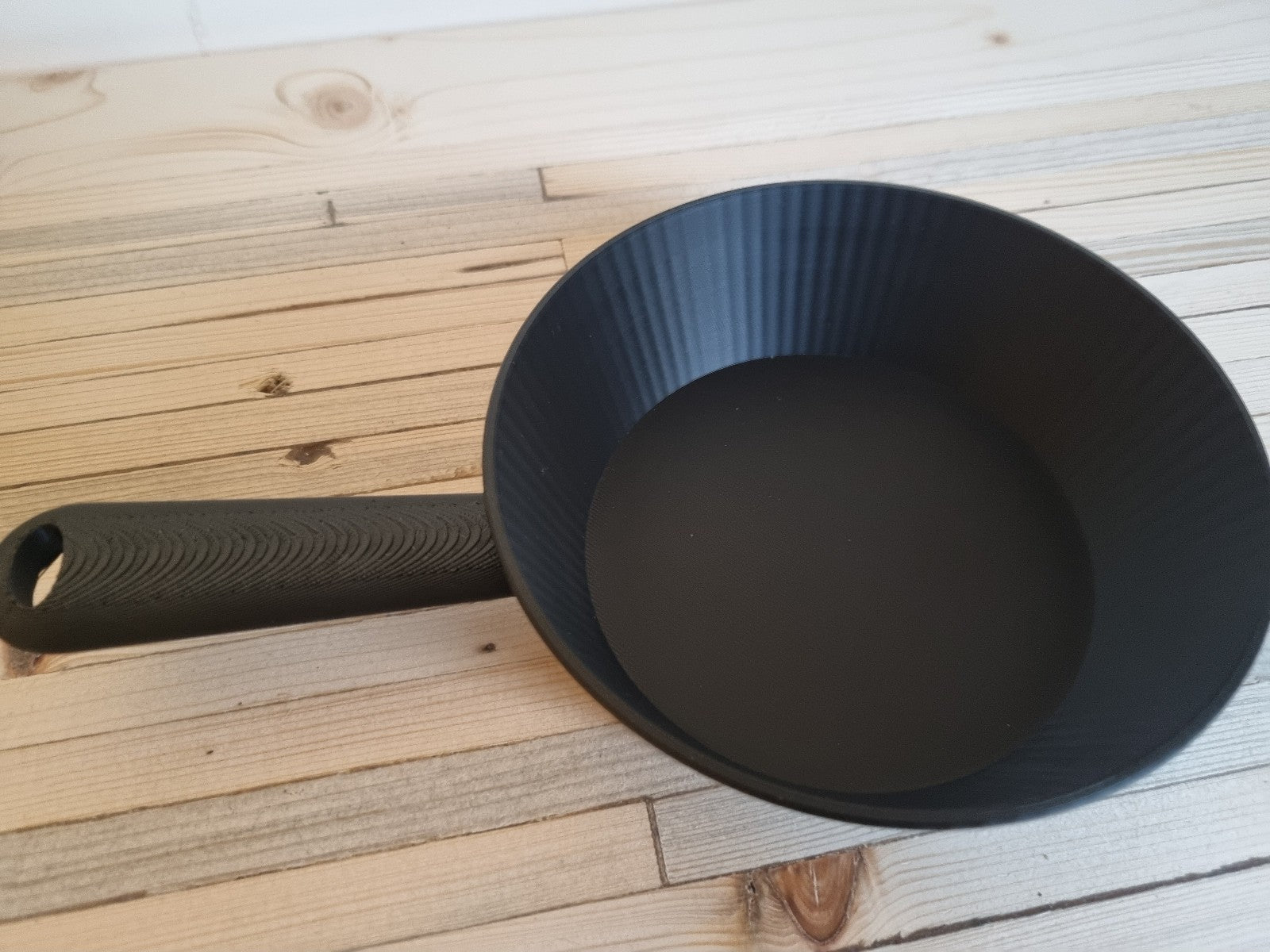 Black  pan on a wooden surface